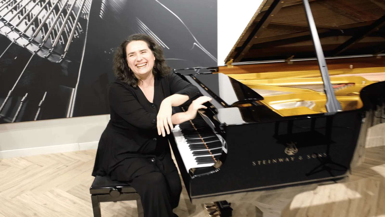 Evelina Vorontsova smiling, seated beside the keyboard of a grand piano